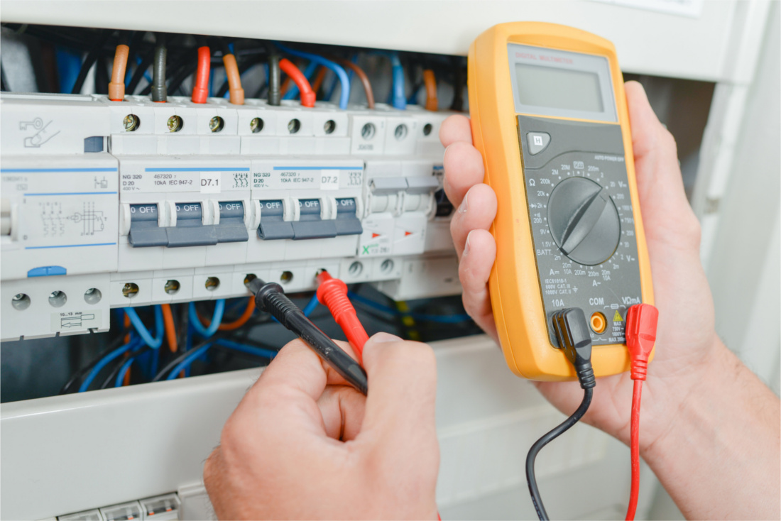 Electrician measuring voltage using multimeter